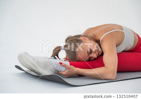 Caucasian woman doing stretching and doing side splits on white background. Caucasian woman doing stretching and doing side splits on white background. 132510407