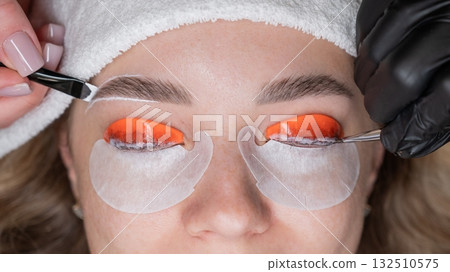 The process of professional lamination and dyeing of eyelashes and eyebrows in the salon. Four-handed procedure.  132510575