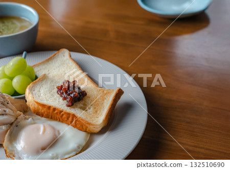 Western-style breakfast of toast, fried egg, chicken ham and Shine Muscat grapes Western-style breakfast of toast, fried egg, chicken ham and Shine Muscat grapes 132510690