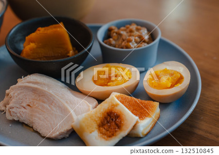 A Japanese-style breakfast plate with boiled eggs, chicken ham, simmered pumpkin, and natto. A Japanese-style breakfast plate with boiled eggs, chicken ham, simmered pumpkin, and natto. 132510845