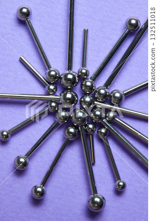 Piercing earrings close-up. On a Violet background. 132511018