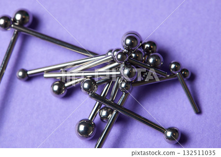 Piercing earrings close-up. On a Violet background. 132511035