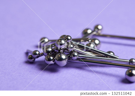 Piercing earrings close-up. On a Violet background. 132511042