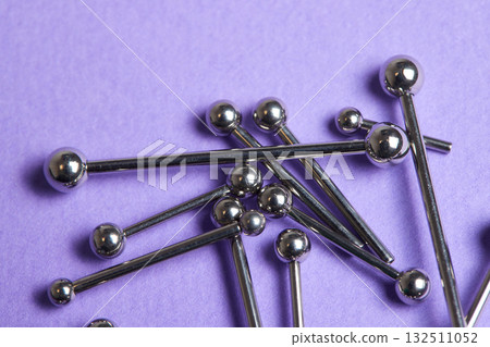 Piercing earrings close-up. On a Violet background. Piercing earrings close-up. On a Violet background. 132511052