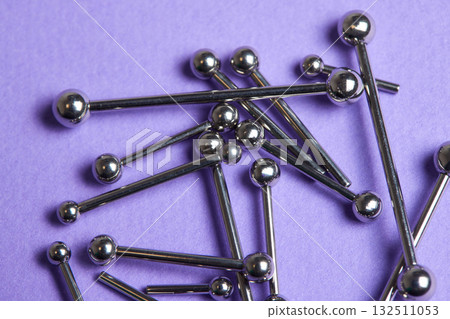 Piercing earrings close-up. On a Violet background. Piercing earrings close-up. On a Violet background. 132511053