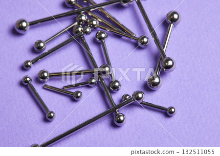 Piercing earrings close-up. On a Violet background. Piercing earrings close-up. On a Violet background. 132511055