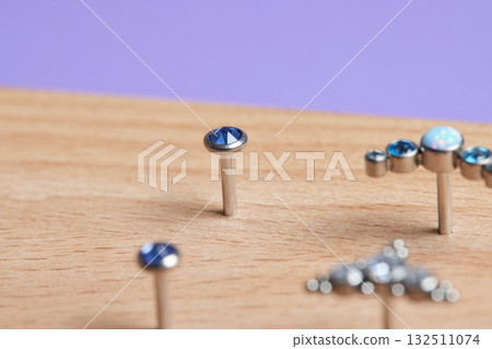 Beautiful piercing jewelry on wooden display. Macro shot. Selective focus. 132511074