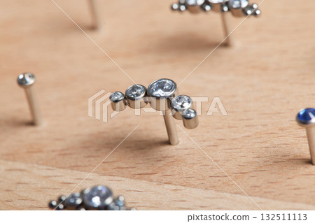 Beautiful piercing jewelry on wooden display. Macro shot. Selective focus. 132511113