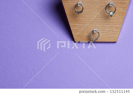 Beautiful piercing jewelry on wooden display. Macro shot. Selective focus. 132511145