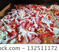 cooking delicious pizza with sausage, tomatoes and cheese at home close-up 132511172
