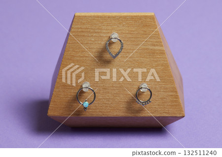 Beautiful piercing jewelry on wooden display. Macro shot. Selective focus. 132511240