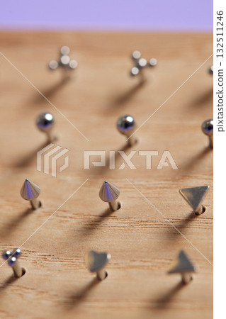 Beautiful piercing jewelry on wooden display. Macro shot. Selective focus. Beautiful piercing jewelry on wooden display. Macro shot. Selective focus. 132511246