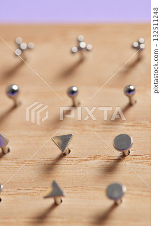 Beautiful piercing jewelry on wooden display. Macro shot. Selective focus. Beautiful piercing jewelry on wooden display. Macro shot. Selective focus. 132511248