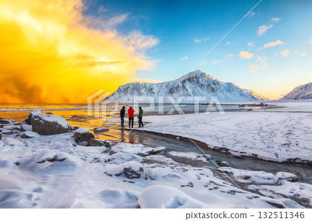 Group of tourist looking  on Skagsanden beach with illuminated clouds during sunrise 132511346