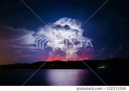 An ominous storm clouds are highlighted by lightning. An ominous storm clouds are highlighted by lightning. 132511506