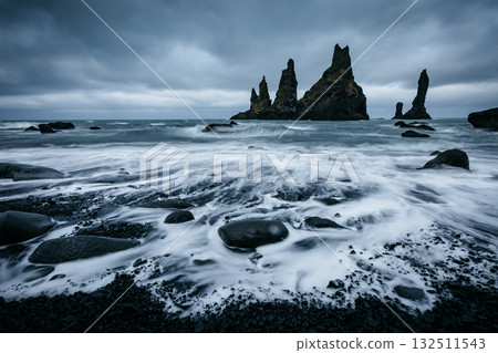 Reynisdrangar basalt rocks or "Troll toes". Location Reynisfjara Beach, Atlantic ocean, Iceland, Europe. 132511543