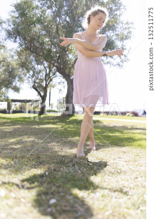 Woman dancing gracefully ballet outdoors in park 132511775