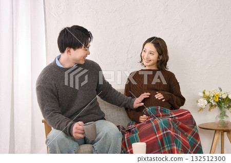 一對年輕夫婦在沙發上休息，孕婦 132512300