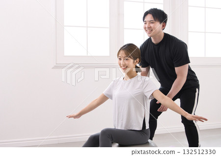 Young woman receiving training from a personal trainer 132512330