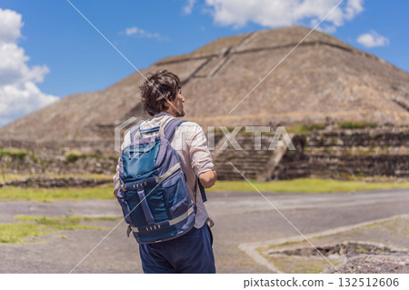 Male tourist posing in front of the pyramids of Teotihuacan in Mexico, enjoying sightseeing, cultural heritage, and travel adventure Male tourist posing in front of the pyramids of Teotihuacan in Mexico, enjoying sightseeing, cultural heritage, and travel adventure 132512606