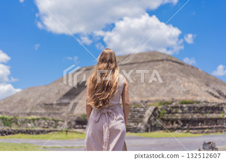 Female tourist standing in front of Teotihuacan pyramids in Mexico, enjoying sightseeing, adventure, and cultural heritage. Travel, tourism, and exploration concept 132512607