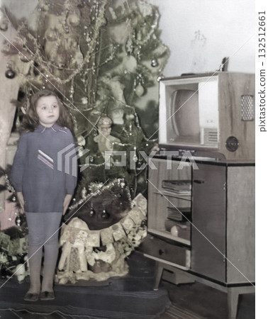 Vintage portrait of a cute little girl by the Christmas tree. Retro photo from 1973. 132512661