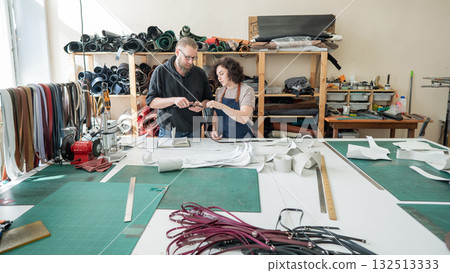 A man and a woman work as tanners in a workshop.  132513333