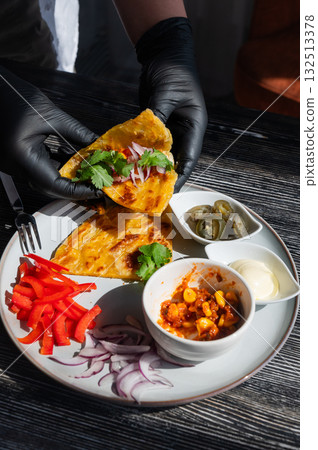 A chef wearing black gloves prepares fajitas. A chef wearing black gloves prepares fajitas. 132513378