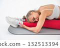 Caucasian woman doing stretching and doing side splits on white background.  132513394