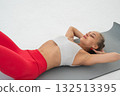 Young woman doing abdominal exercises on white background. 132513395