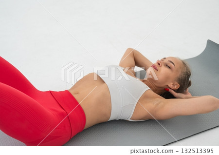 Young woman doing abdominal exercises on white background. Young woman doing abdominal exercises on white background. 132513395