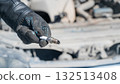 Caucasian man changing spark plugs in car.  132513408