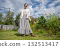 Young Caucasian woman watering flowers in the garden.  132513417