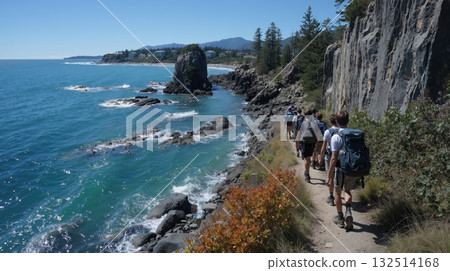 Group of students hiking along rocky coastal trail with scenic ocean views 132514168