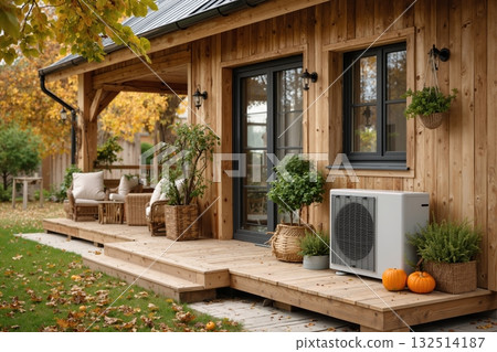 Cozy wooden cabin with autumn decor, patio seating, and modern heat pump surrounded by lush greenery and orange pumpkins 132514187