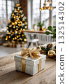 Elegant christmas gift with golden ribbon in decorated room and christmas tree in background 132514302