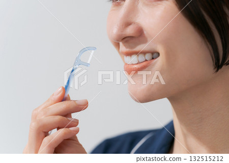 年輕女子使用牙線 年輕女子使用牙線 132515212