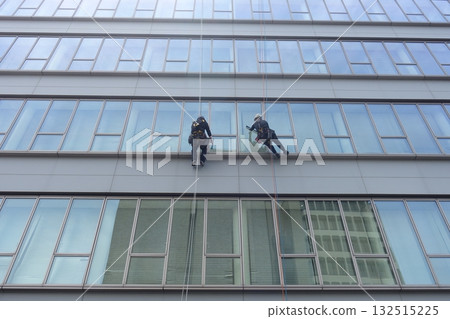 Workers cleaning windows in a high-rise building 132515225