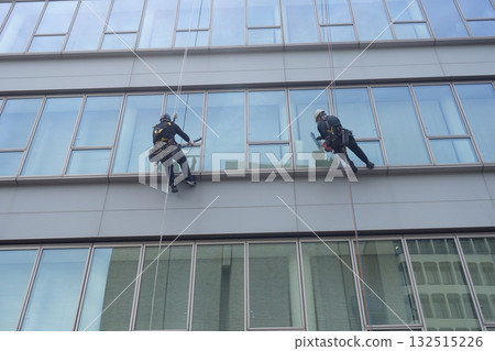 Workers cleaning windows in a high-rise building 132515226
