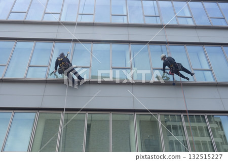 Workers cleaning windows in a high-rise building 132515227