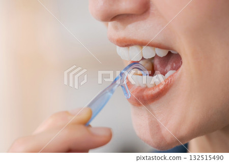 一名婦女的嘴巴使用牙線 一名婦女的嘴巴使用牙線 132515490