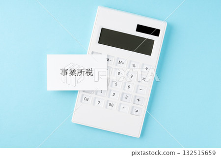 Business tax lettering and calculator on a light blue background Business tax lettering and calculator on a light blue background 132515659