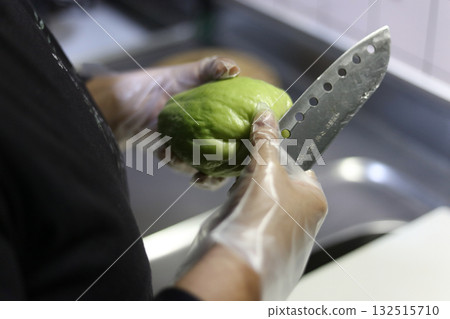 A woman peeling a chayote A woman peeling a chayote 132515710