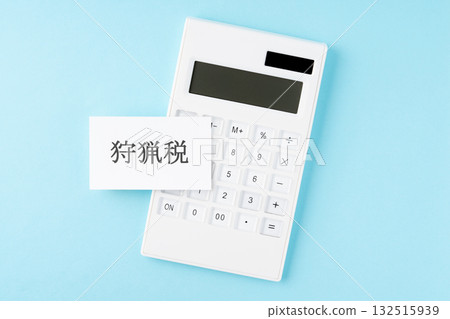 Hunting tax text and calculator on light blue background Hunting tax text and calculator on light blue background 132515939