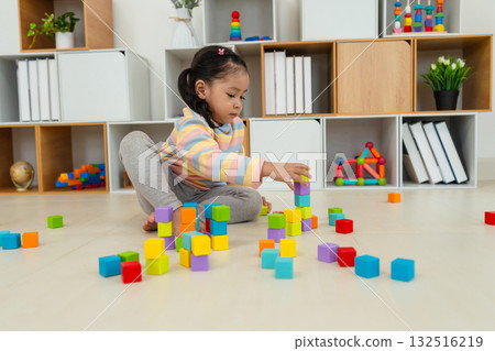 toddler girl playing block toy to stacks building cubes at home toddler girl playing block toy to stacks building cubes at home 132516219
