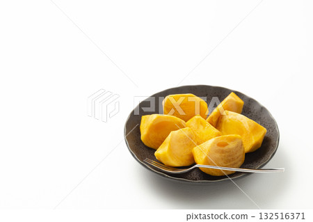 Persimmons on a plate on a white background 132516371
