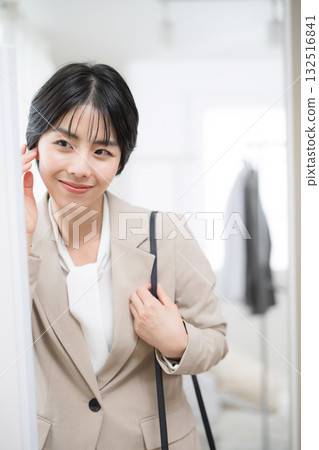 A woman in a suit checking her appearance before going to work. I'm off. 132516841