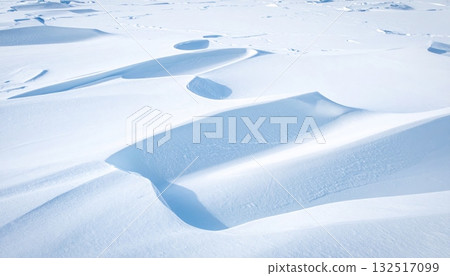 Snowy winter landscape with a blue sky, featuring a vast iceberg and majestic mountains, evoking the cold beauty of nature and ice 132517099