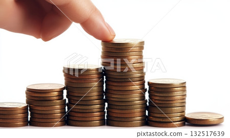 Ascending stacks of golden coins symbolize investment growth, with a finger reaching the highest stack, representing financial success and wealth accumulation 132517639