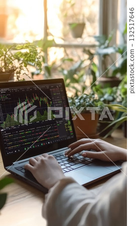 Trader working from home office analyzing cryptocurrency investment charts displayed on laptop screen, making strategic decisions in online trading with bitcoin and other digital assets 132517646
